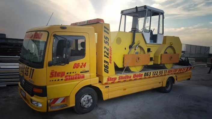 Bezbedno natovaren valjak žute boje za transport na žuti šlep kamion šlep službe djole