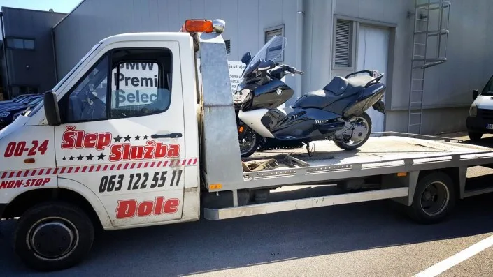Šlep služba djole sa belim šlep kamionom prevozi crni BMW skuter